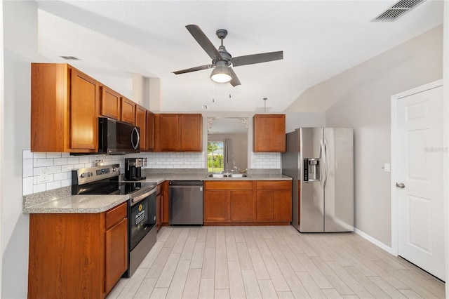 16605 SW 31st Cir, Ocala, FL 34473 - kitchen with stainless steel appliances, brown cabinets, tasteful backsplash, ceiling fan, and vaulted ceiling