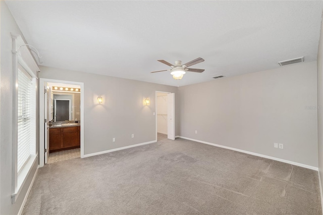 16605 SW 31st Cir, Ocala, FL 34473 - unfurnished bedroom with light carpet, a walk in closet, ensuite bathroom, a ceiling fan, and a closet
