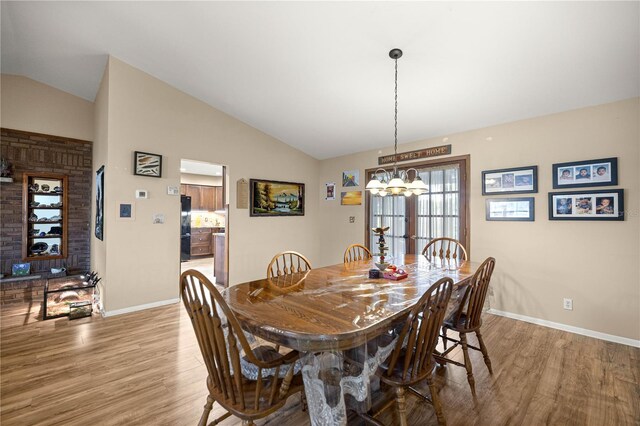 6497 W Anthony Rd, Ocala, FL 34479 - dining space with light wood-type flooring, vaulted ceiling, baseboards, and a chandelier
