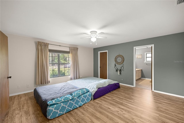6497 W Anthony Rd, Ocala, FL 34479 - bedroom featuring light wood-style floors, baseboards, ensuite bath, and ceiling fan