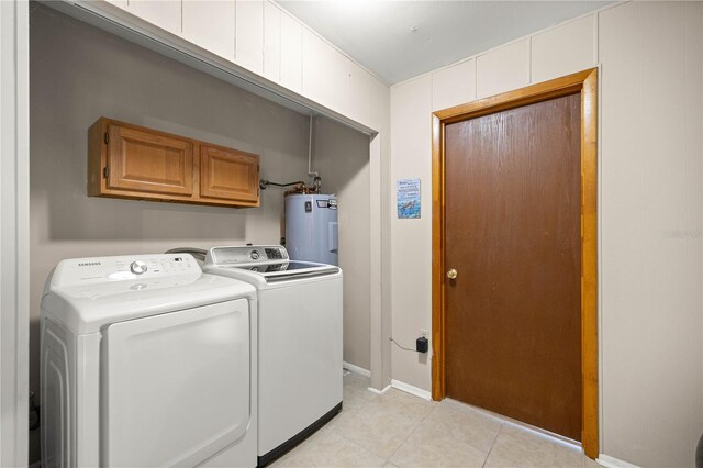6497 W Anthony Rd, Ocala, FL 34479 - laundry area featuring water heater, washing machine and dryer, light tile patterned floors, cabinet space, and baseboards