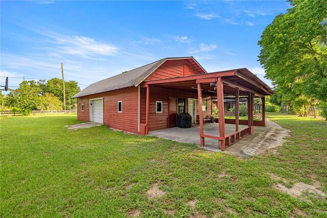 6497 W Anthony Rd, Ocala, FL 34479 - view of side of property with a lawn, a detached garage, a patio, and an outbuilding