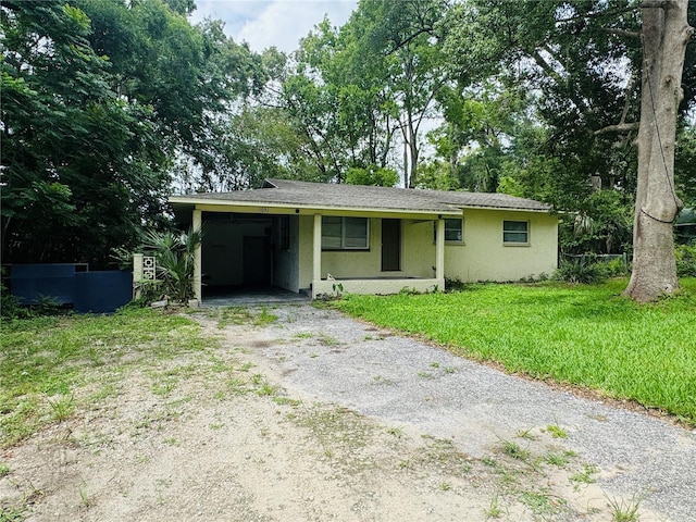 1051 SE 28th Rd, Ocala, FL 34471 - view of front facade with driveway, stucco siding, a front yard, and an attached carport