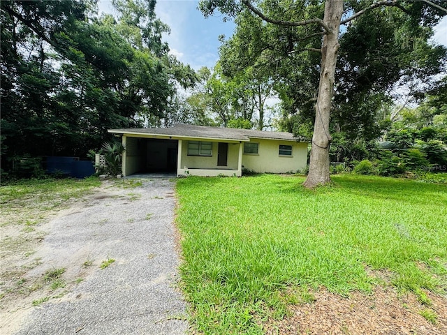 1051 SE 28th Rd, Ocala, FL 34471 - view of front of home featuring asphalt driveway, stucco siding, a front yard, and an attached carport