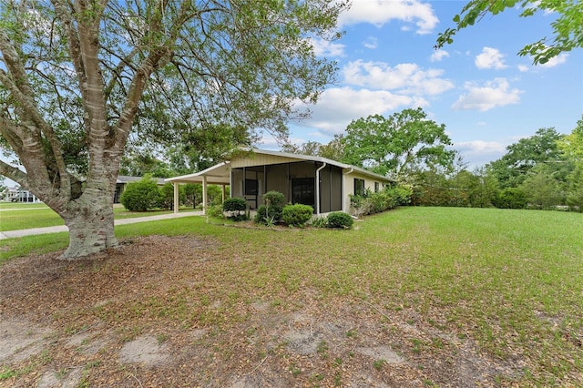 10012 SW 88th Ct, Ocala, FL 34481 - view of side of home featuring a lawn, an attached carport, a sunroom, and driveway