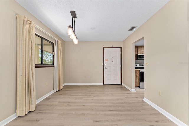 10012 SW 88th Ct, Ocala, FL 34481 - unfurnished dining area featuring light wood-style floors, baseboards, and a textured ceiling