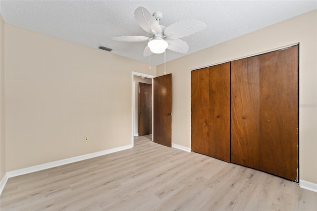 10012 SW 88th Ct, Ocala, FL 34481 - unfurnished bedroom with light wood-style flooring, a closet, baseboards, and a textured ceiling