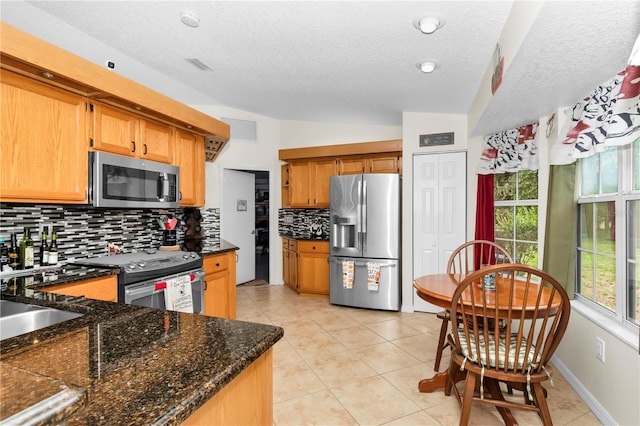10806 SW 86th Ave, Ocala, FL 34481 - kitchen featuring appliances with stainless steel finishes, tasteful backsplash, a textured ceiling, vaulted ceiling, and light tile patterned floors