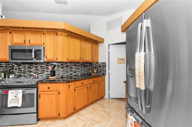 10806 SW 86th Ave, Ocala, FL 34481 - kitchen with appliances with stainless steel finishes, tasteful backsplash, light tile patterned floors, dark stone counters, and brown cabinets