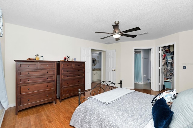 10806 SW 86th Ave, Ocala, FL 34481 - bedroom featuring light wood-style floors, ensuite bathroom, a walk in closet, a closet, and a textured ceiling
