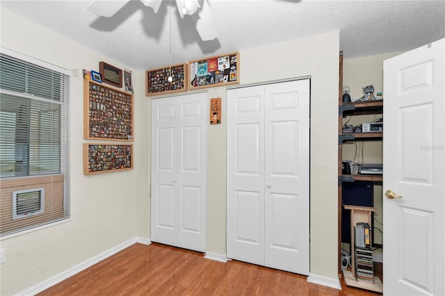 10806 SW 86th Ave, Ocala, FL 34481 - bedroom with wood finished floors, a closet, baseboards, a textured ceiling, and a ceiling fan