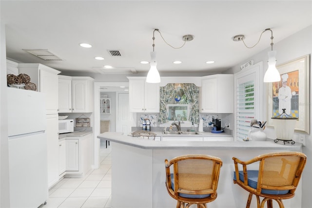 12335 SE 130th Ct, Ocklawaha, FL 32179 - kitchen with white appliances, white cabinetry, light countertops, pendant lighting, and recessed lighting