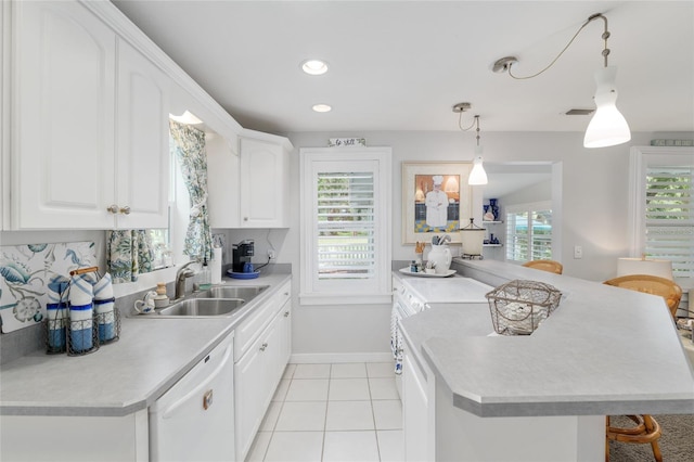 12335 SE 130th Ct, Ocklawaha, FL 32179 - kitchen featuring white dishwasher, a sink, baseboards, light countertops, and pendant lighting