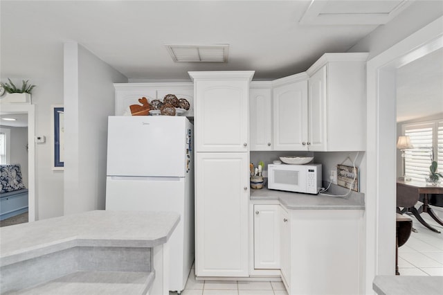 12335 SE 130th Ct, Ocklawaha, FL 32179 - kitchen featuring white appliances, light tile patterned floors, white cabinetry, and light countertops