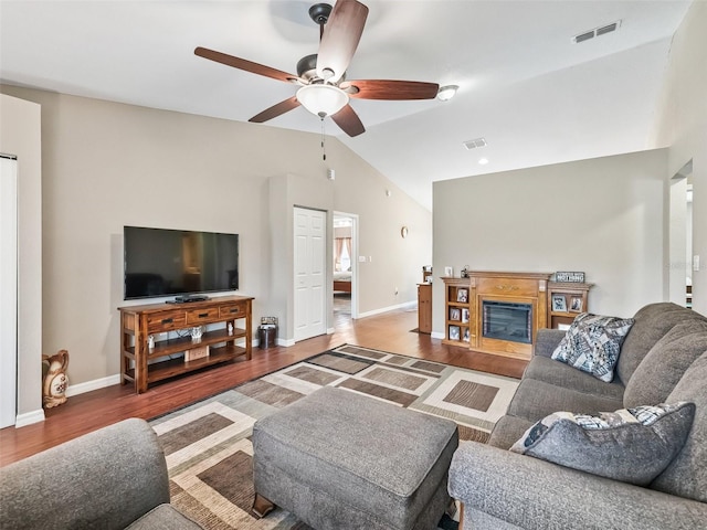 11 Pecan Course Loop, Ocala, FL 34472 - living room featuring a ceiling fan, vaulted ceiling, wood finished floors, baseboards, and a glass covered fireplace