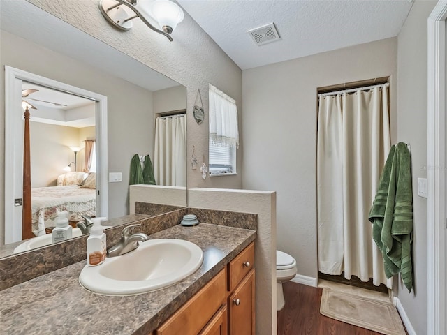 11 Pecan Course Loop, Ocala, FL 34472 - ensuite bathroom featuring wood finished floors, toilet, vanity, baseboards, and a shower with curtain