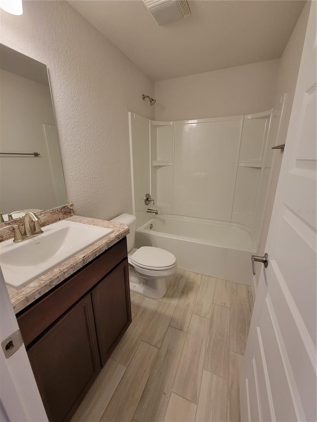 15055 SW 25th Cir, Ocala, FL 34473 - bathroom featuring vanity, toilet, wood finished floors,  shower combination, and a textured wall