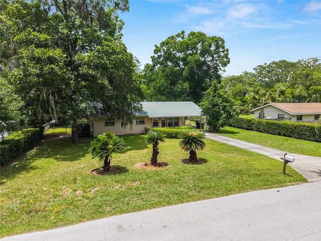 3621 SE 12th Pl, Ocala, FL 34471 - ranch-style home featuring driveway, a front yard, a carport, and metal roof