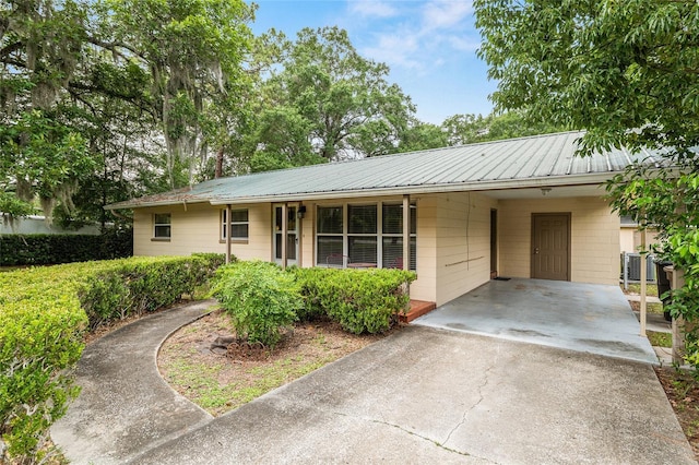 3621 SE 12th Pl, Ocala, FL 34471 - ranch-style home with asphalt driveway, an attached carport, metal roof, and central AC
