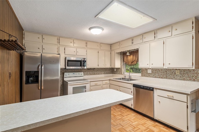 3621 SE 12th Pl, Ocala, FL 34471 - kitchen featuring appliances with stainless steel finishes, a sink, light countertops, cream cabinetry, and a textured ceiling