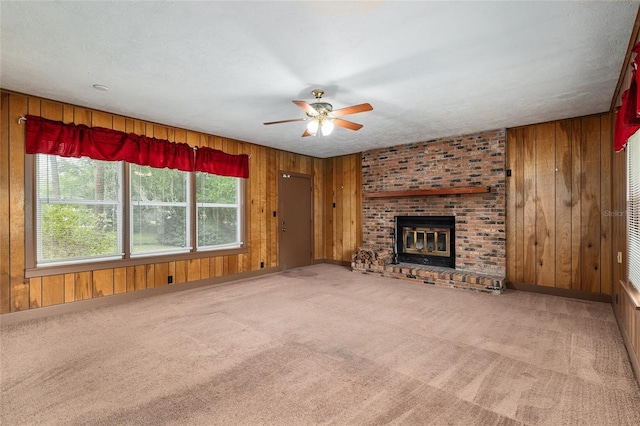 3621 SE 12th Pl, Ocala, FL 34471 - unfurnished living room featuring wooden walls, a ceiling fan, carpet, a brick fireplace, and baseboards