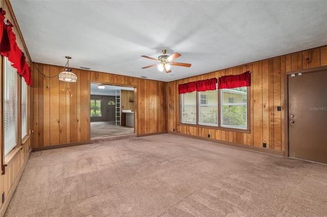 3621 SE 12th Pl, Ocala, FL 34471 - unfurnished living room featuring plenty of natural light, carpet floors, a ceiling fan, wood walls, and baseboards