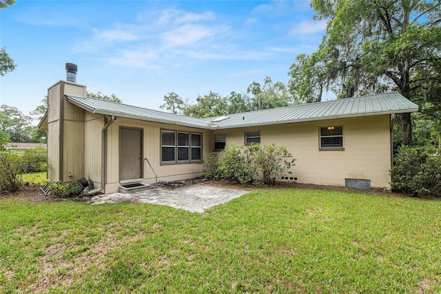 3621 SE 12th Pl, Ocala, FL 34471 - back of house with a chimney, metal roof, and a lawn