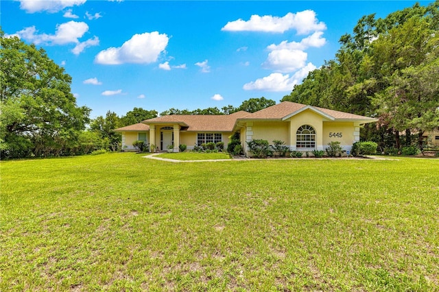 5445 NE Anthony Rd, Ocala, FL 34475 - ranch-style house with stucco siding and a front lawn