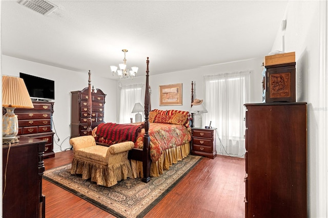 5445 NE Anthony Rd, Ocala, FL 34475 - bedroom with a chandelier and dark wood-style floors