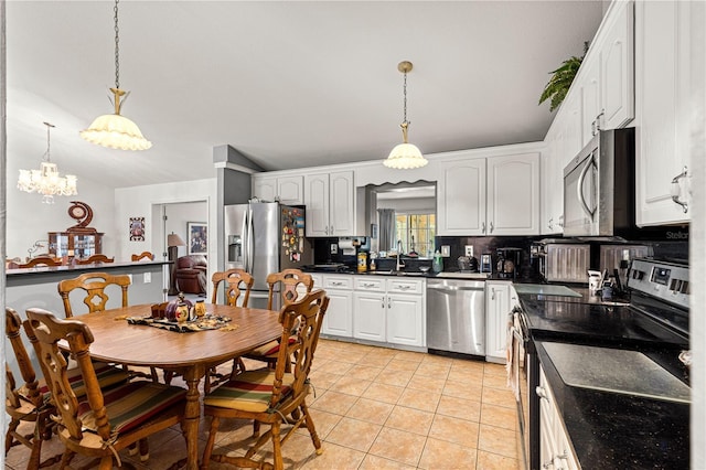 5445 NE Anthony Rd, Ocala, FL 34475 - kitchen with appliances with stainless steel finishes, dark countertops, white cabinetry, and light tile patterned floors