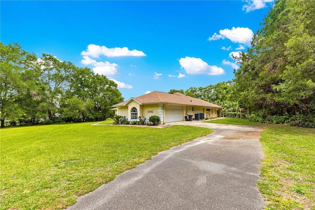 5445 NE Anthony Rd, Ocala, FL 34475 - ranch-style house with a garage, asphalt driveway, a front lawn, and cooling unit