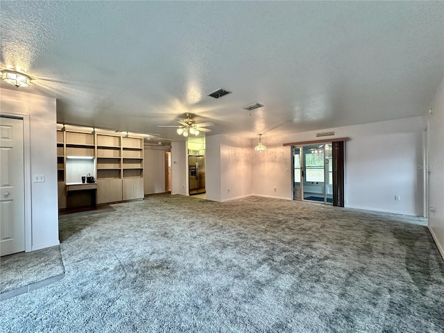 2020 W Snowy Egret Pl, Citrus Springs, FL 34434 - unfurnished living room featuring a textured ceiling, carpet, a ceiling fan, and baseboards