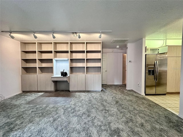 2020 W Snowy Egret Pl, Citrus Springs, FL 34434 - unfurnished living room with rail lighting, carpet flooring, a textured ceiling, and baseboards