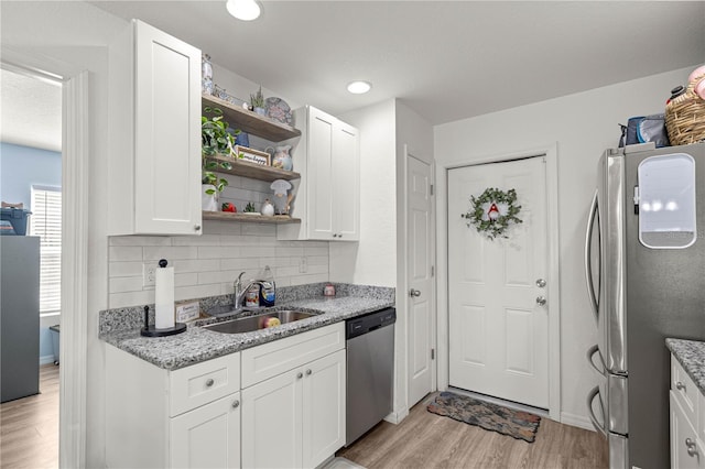 5063 SE 168th Ter, Ocklawaha, FL 32179 - kitchen with stainless steel appliances, a sink, open shelves, light wood-style flooring, and backsplash
