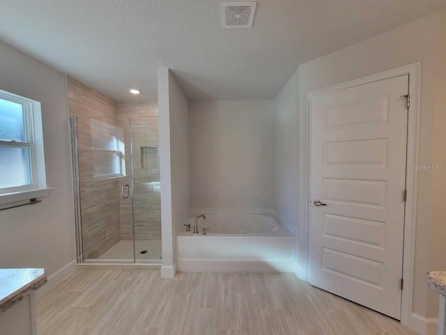 13977 SW 81st St, Dunnellon, FL 34432 - bathroom with a garden tub, a shower stall, baseboards, wood finished floors, and vanity