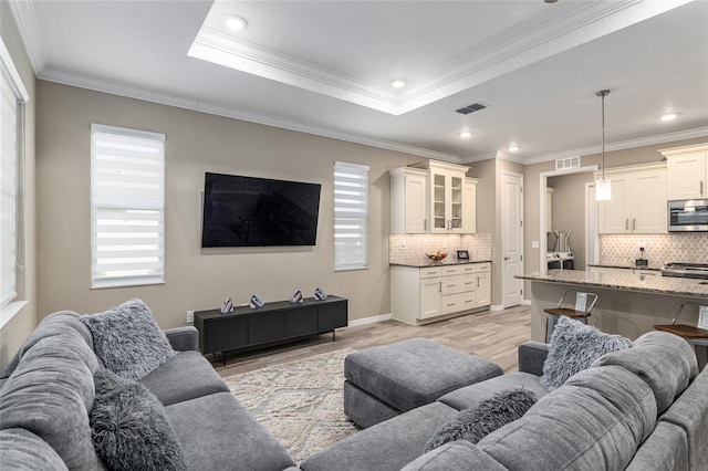 8878 SW 103rd Cir, Ocala, FL 34481 - living room with light wood-style floors, ornamental molding, recessed lighting, a raised ceiling, and baseboards