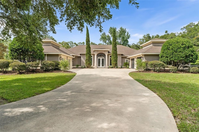 659 NW 155th Way, Newberry, FL 32669 - ranch-style house featuring a garage, french doors, concrete driveway, stucco siding, and a front yard