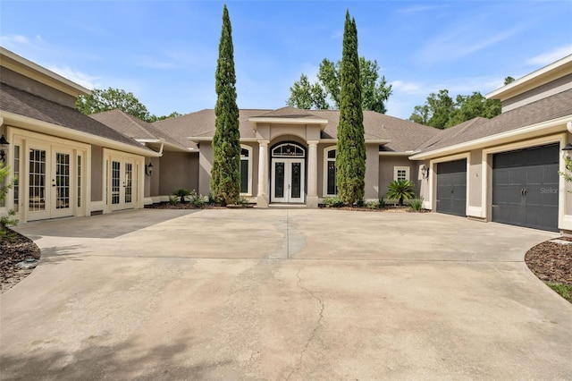 659 NW 155th Way, Newberry, FL 32669 - view of front of home featuring french doors, stucco siding, driveway, a garage, and a shingled roof