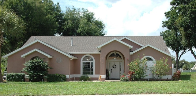 14126 Greater Pines Blvd, Clermont, FL 34711 - view of front of house featuring stucco siding, a front yard, and a shingled roof