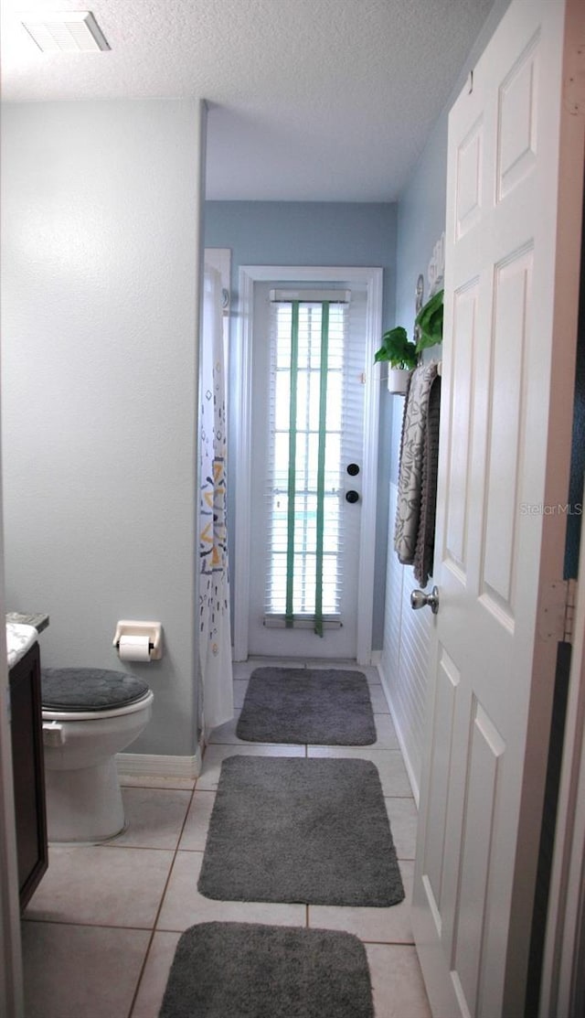 14126 Greater Pines Blvd, Clermont, FL 34711 - bathroom featuring vanity, toilet, tile patterned flooring, a textured ceiling, and curtained shower