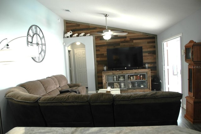 14126 Greater Pines Blvd, Clermont, FL 34711 - living area with vaulted ceiling, wooden walls, an accent wall, a ceiling fan, and wood finished floors