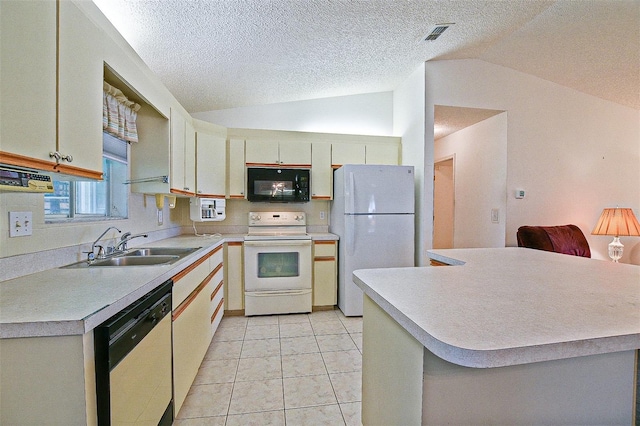 10699 SE 178th St, Summerfield, FL 34491 - kitchen with white appliances, vaulted ceiling, light countertops, a textured ceiling, and light tile patterned floors