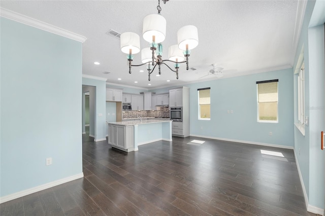 9805 SW 95th Loop, Ocala, FL 34481 - unfurnished living room featuring ornamental molding, a chandelier, baseboards, dark wood finished floors, and recessed lighting