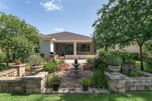 9805 SW 95th Loop, Ocala, FL 34481 - back of house with a patio, stucco siding, roof with shingles, and a sunroom