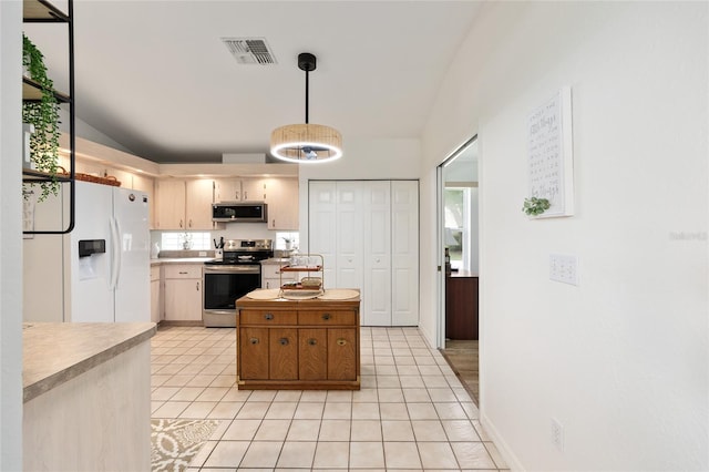 11051 SW 73rd Ct, Ocala, FL 34476 - kitchen featuring stainless steel appliances, light countertops, light tile patterned flooring, vaulted ceiling, and decorative light fixtures