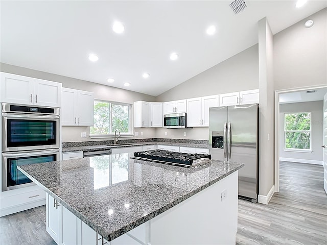 226 Locust Ln, Ocala, FL 34472 - kitchen with stainless steel appliances, a kitchen island, white cabinetry, stone counters, and light wood-style floors