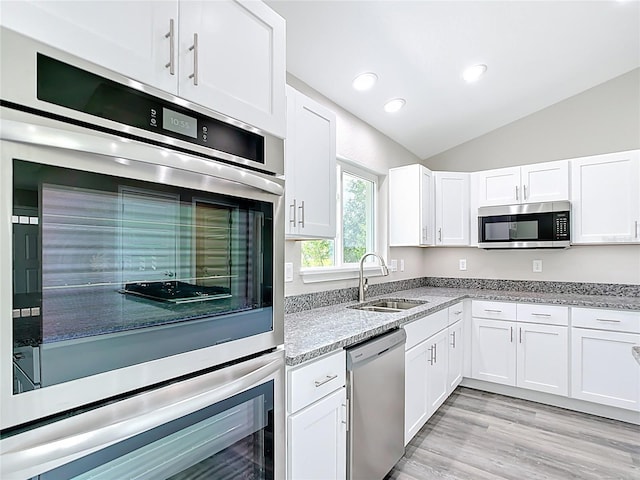 226 Locust Ln, Ocala, FL 34472 - kitchen with appliances with stainless steel finishes, white cabinets, light stone counters, lofted ceiling, and recessed lighting
