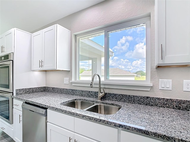 226 Locust Ln, Ocala, FL 34472 - kitchen featuring stainless steel appliances, white cabinetry, a textured wall, and stone counters
