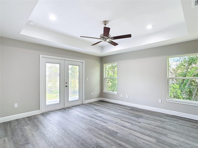 226 Locust Ln, Ocala, FL 34472 - empty room featuring a tray ceiling, plenty of natural light, wood finished floors, and recessed lighting