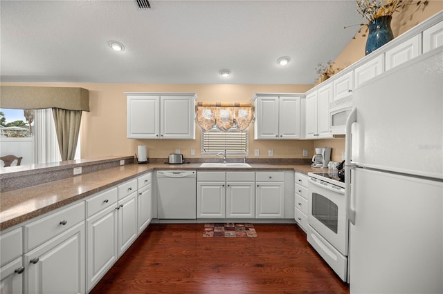 1204 Flamingo Pl, The Villages, FL 32162 - kitchen with white appliances, a sink, white cabinetry, dark wood-style flooring, and recessed lighting